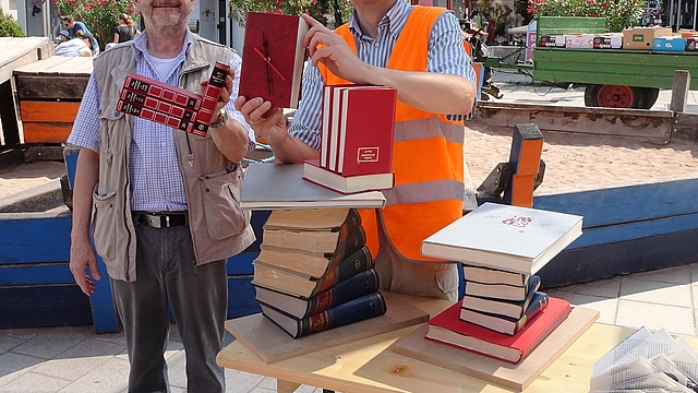 Beim Bücherflohmarkt werden auch Basteleien aus alten Büchern dargeboten – wie eine Bücher-Uhr oder kleine Stehtische